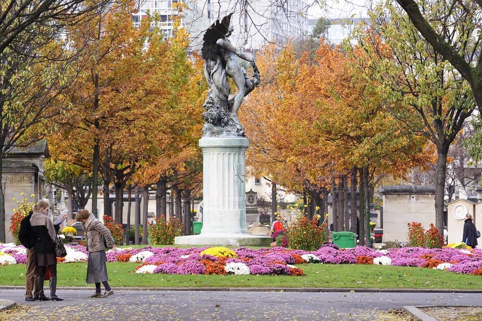 Statue on a column surrounded by flowers.