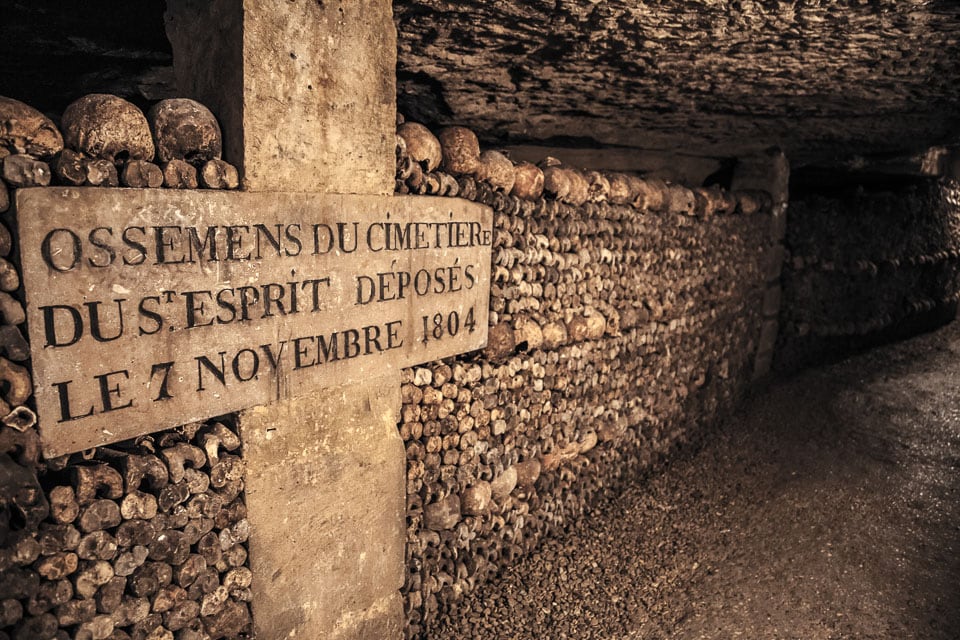 Cross and wall of bones in the Paris Catacombs.