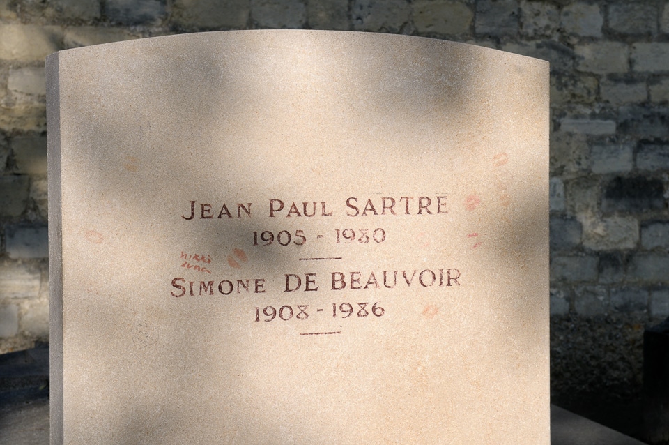 Red lip prints on the tombstone of Jean-Paul Sartre and Simone de Beauvoir.