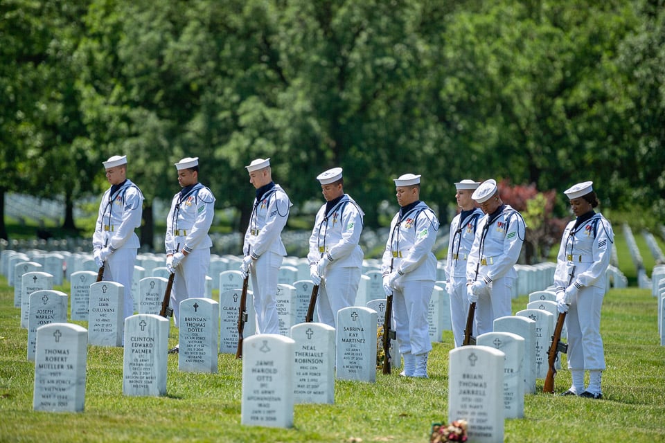 Soldiers standing in the cemetery during a funeral.