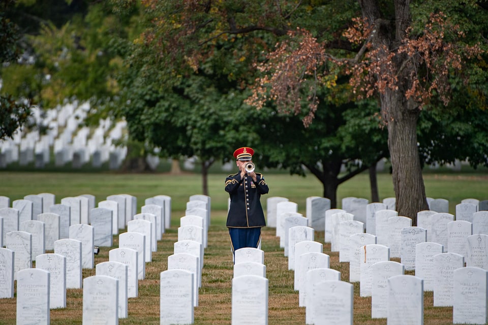 Uniformed trumpet player in the cemetery.