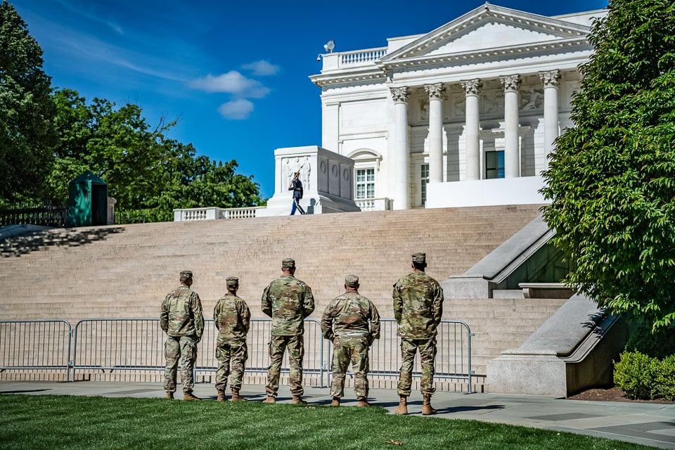 Soldiers dressed in camo looking at the Tomb of the Unknown Soldier from the bottom of the stairs.