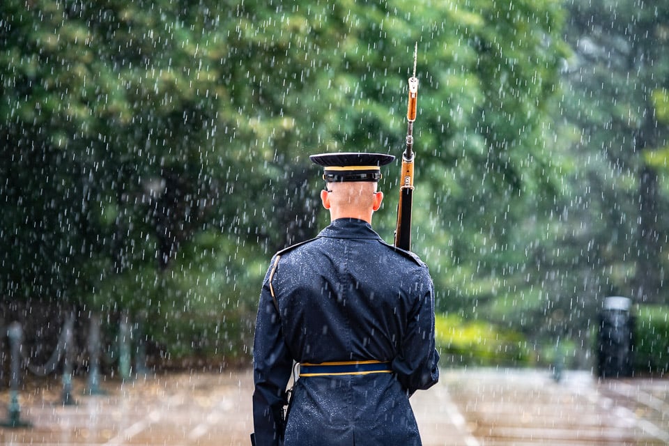 Tomb guard in the rain with back to the camera.