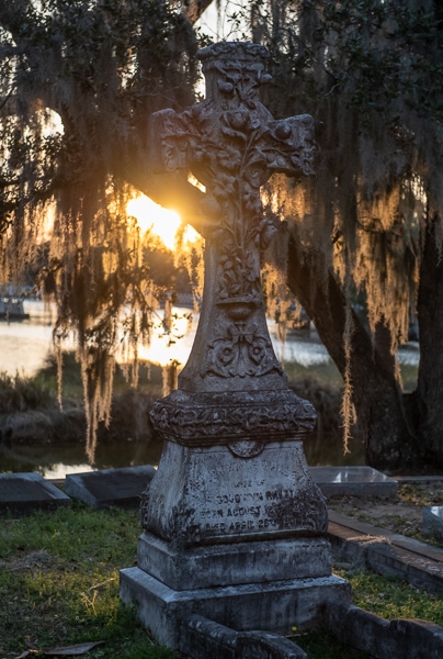 Sculpted cross tombstone at sunset.