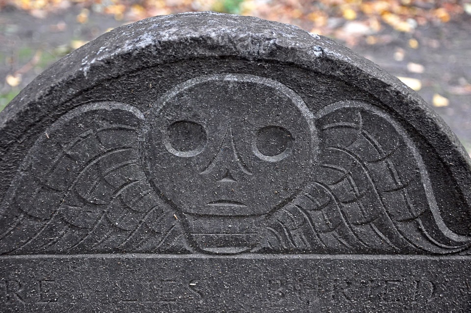 Skull with wings on a tombstone.