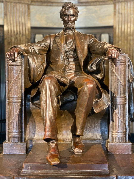 Bronze statue of Abraham Lincoln sitting in a chair.