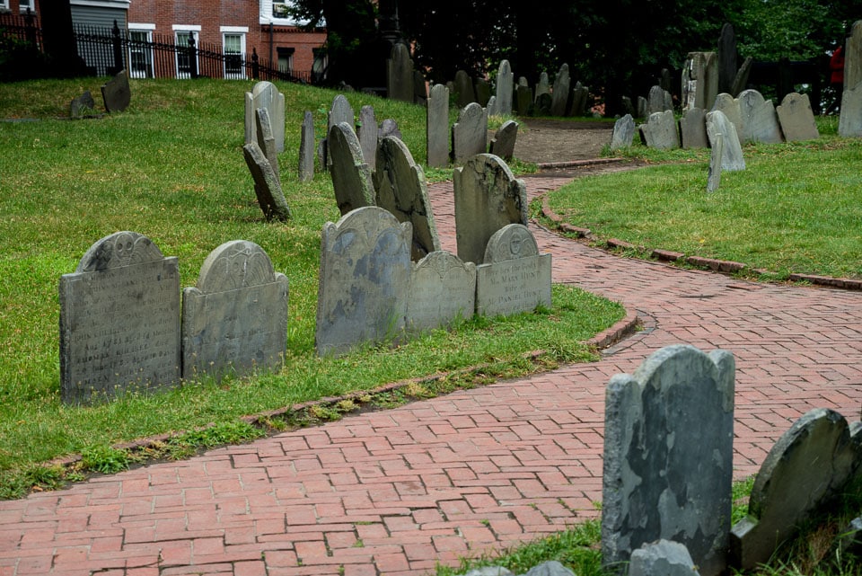 Tombstones lining a red brick path.
