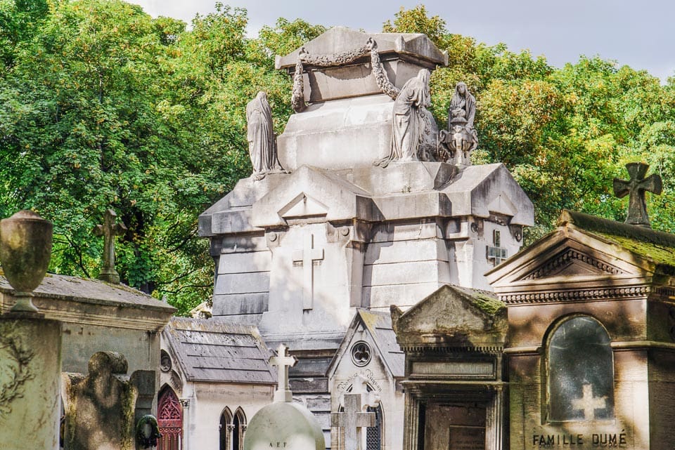 Large mausoleum towering overing smaller ones in a Paris cemetery.