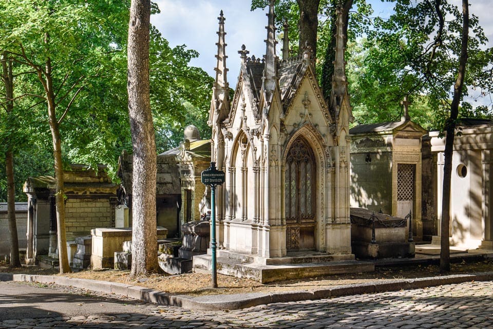 Tombs and mausoleums at a path intersection in Montmartre Cemetery.