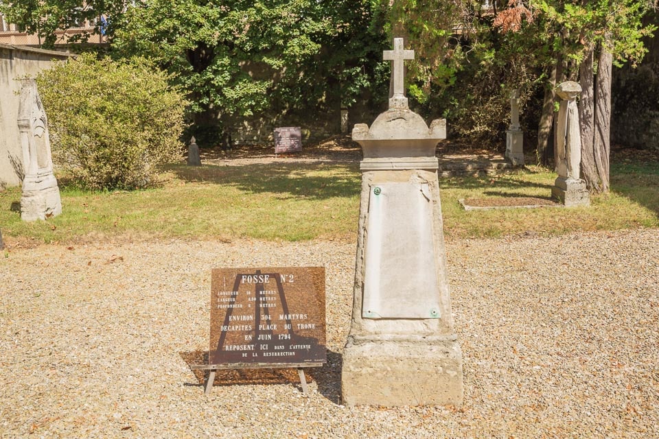 Memorial stone and sign at a common grave in Picpus Cemetery.