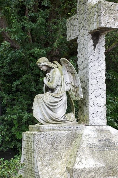 Cross with a mourning angel in Kensal Green Cemetery.