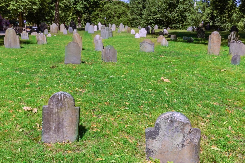 Old tombstones standing in a patch of grass.