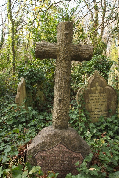 Cross shaped tombstone that was carved to look like tree bark. 