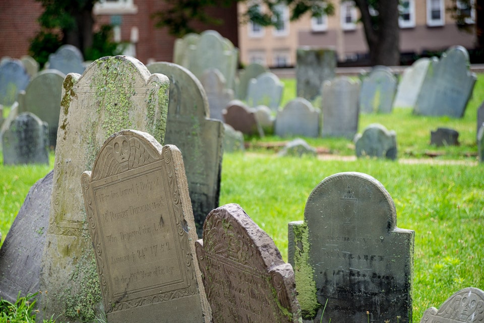 A group of leaning tombstones in a Boston cemetery.