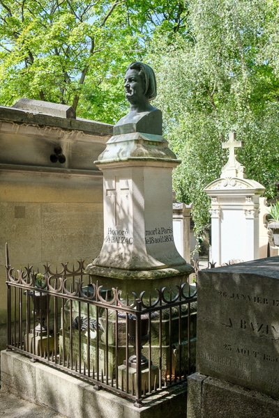 A bust of Honore de Balzac sits atop a pedestal marking his grave.