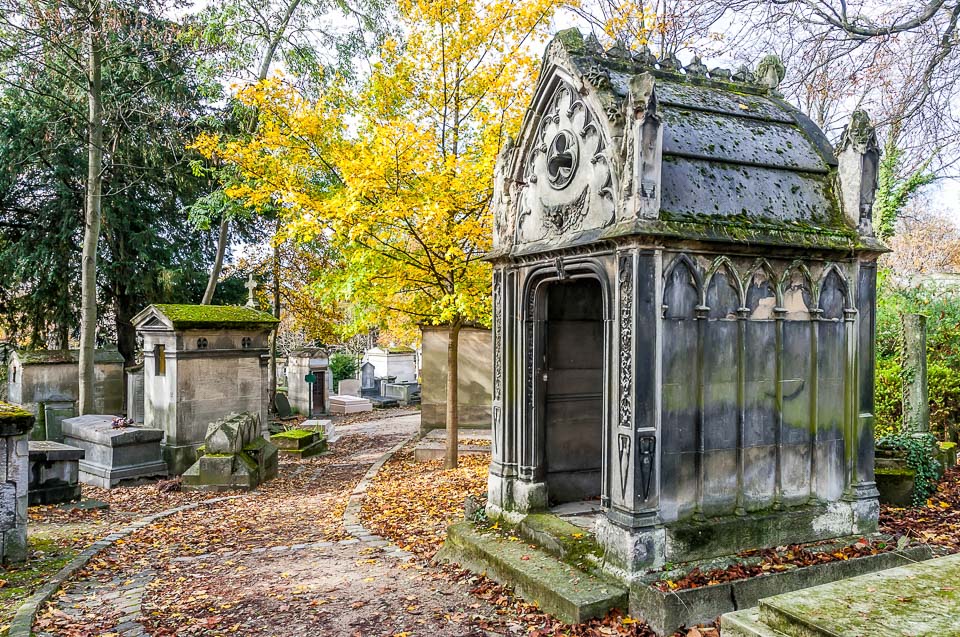 Tombs beside a tree-shaded path in Père Lachaise Cemetery.