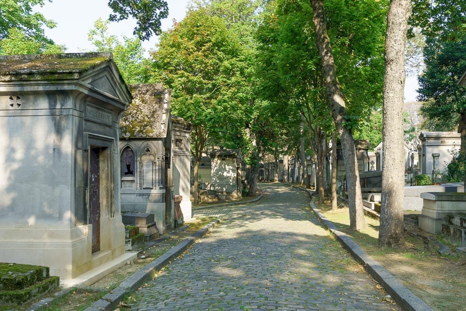 Path lined with tombs and trees in Père Lachaise Cemetery.