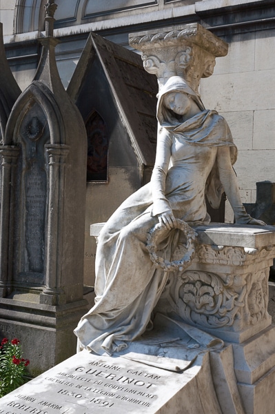 Mourning woman sculpture on a grave in Pere Lachaise Cemetery.