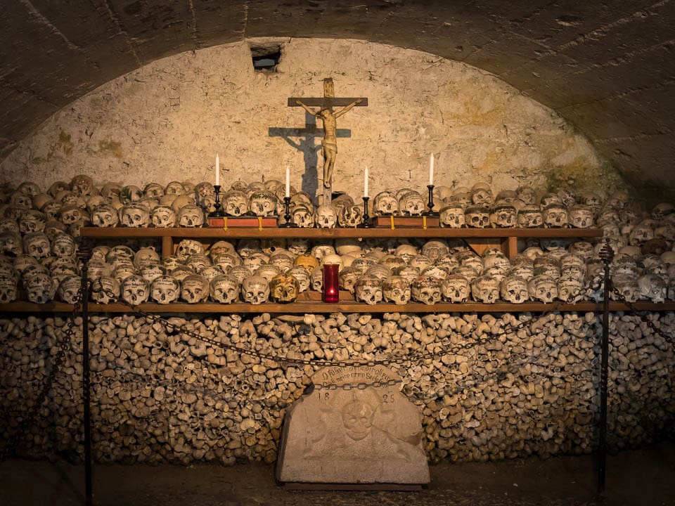 A shelf of skulls above a pile of bones in the Hallstatt Charnel House.