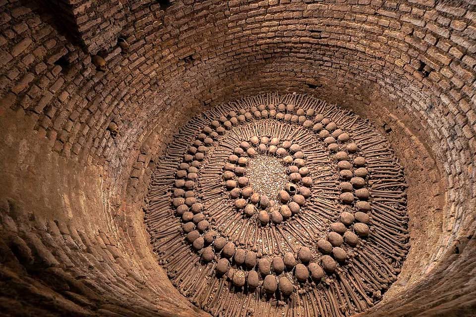 Bones arranged in a pattern at the bottom of a well in the Lima Catacombs.