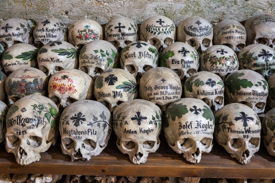 Rows of painted skulls on a shelf in the Hallstatt Charnel House.