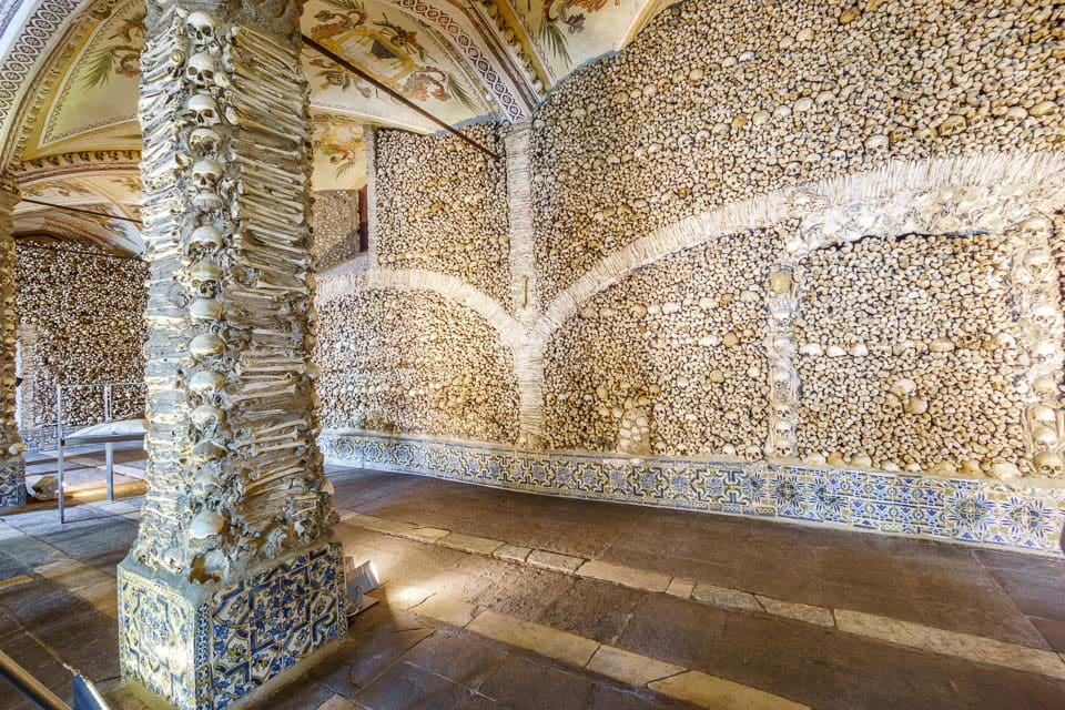 Walls and a column covered with bones inside the Evora Chapel of Bones. 