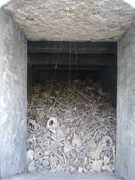 Looking through a window at a pile of bones in Douaumont Ossuary.