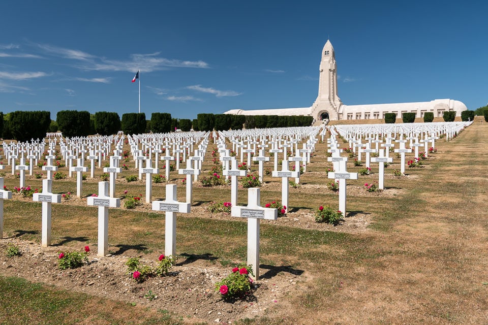 Douaumont Ossuary behind rows of crosses in a cemetery.