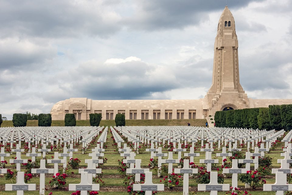 Douaumont Ossuary behind rows of crosses in a cemetery.