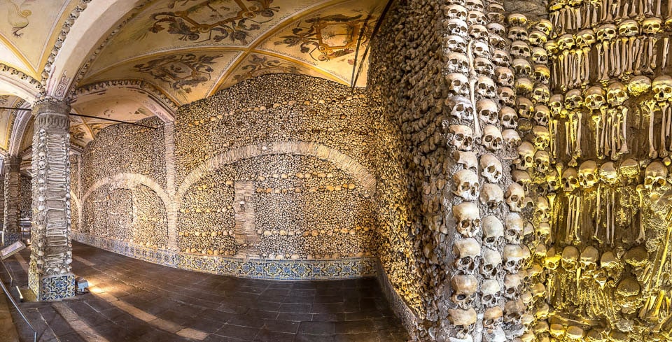 Painted ceiling above bone covered walls and pillars inside the Capela dos Ossos.